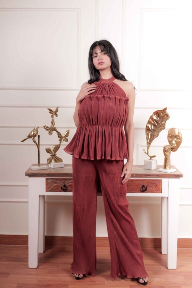 Fashion portrait captured at Lens Grove Studio, a professional photo and video shoot rental space in Delhi, featuring a female model wearing a coordinated rust-colored outfit, posing against a classic white paneled backdrop with balanced studio lighting for editorial and portfolio photography.