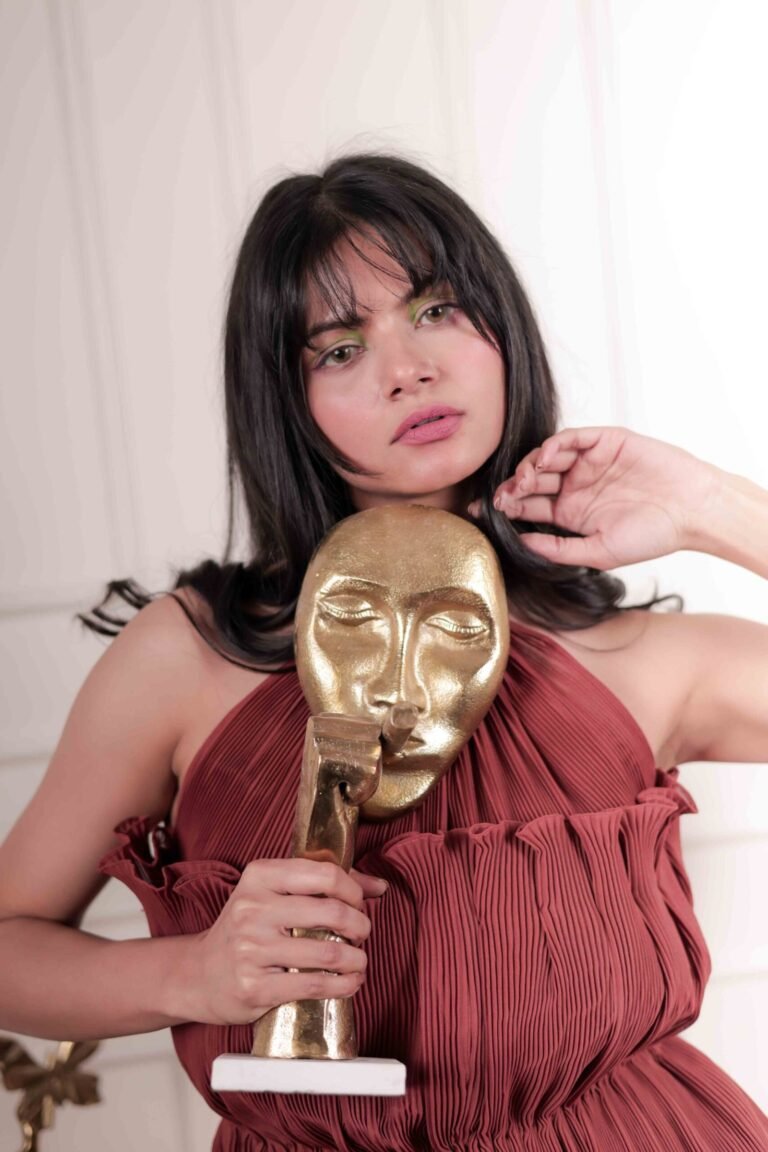 Fashion portrait captured at Lens Grove Studio, a professional photo and video shoot rental space in Delhi, featuring a female model wearing a coordinated rust-colored outfit, posing against a classic white paneled backdrop with balanced studio lighting for editorial and portfolio photography.