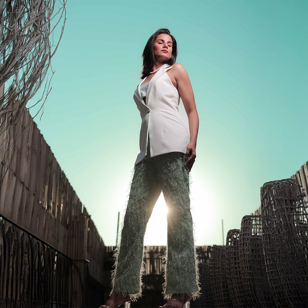 Studio fashion portrait shot at Lens Grove Studio, a professional photo and video shoot rental space in Delhi, featuring a female model wearing a white satin shirt, black skirt, and sneakers, posing against a clean neutral backdrop with soft studio lighting for editorial and portfolio photography.
