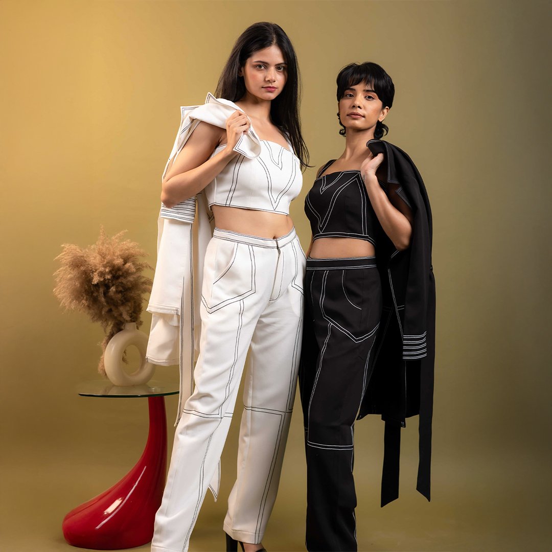 Fashion photoshoot captured at Lens Grove Studio, a professional photo and video shoot rental space in Delhi, featuring two female models posing in coordinated printed co-ord outfits against a vibrant pink backdrop, styled for editorial, brand, and fashion photography.